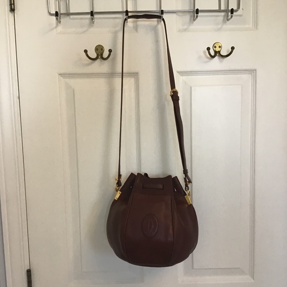 Iconic Cartier leather bucket shoulder bag with dust cover.